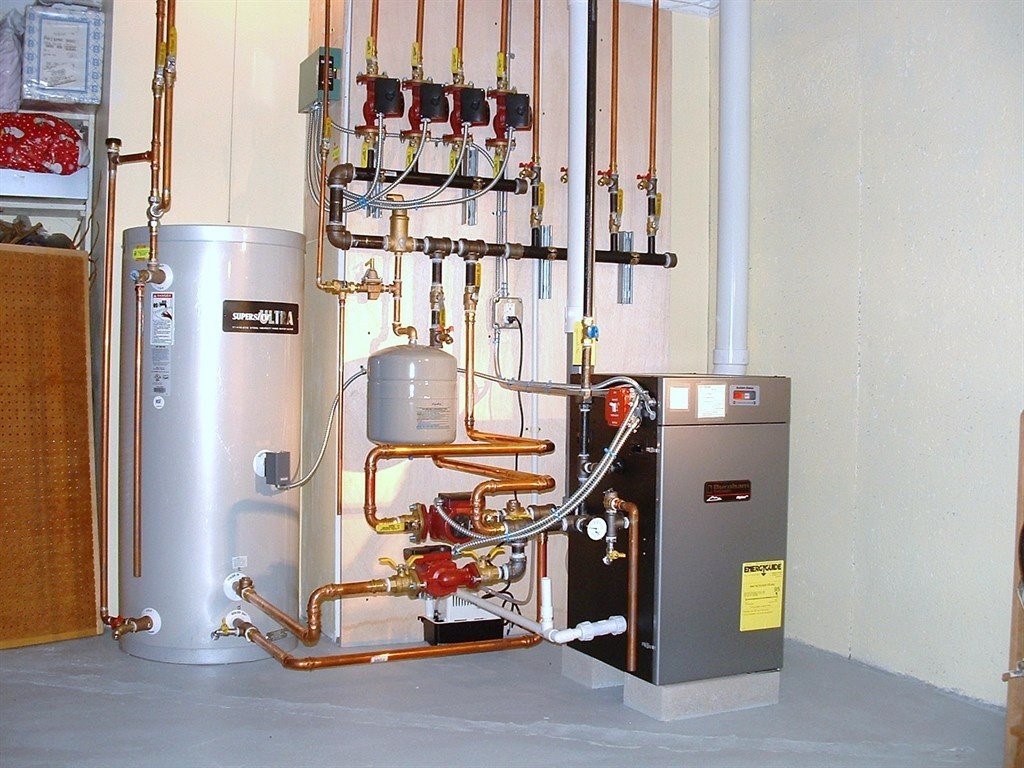 Professional plumber installing a compact, energy-efficient tankless water heater in a residential utility room, providing endless hot water supply